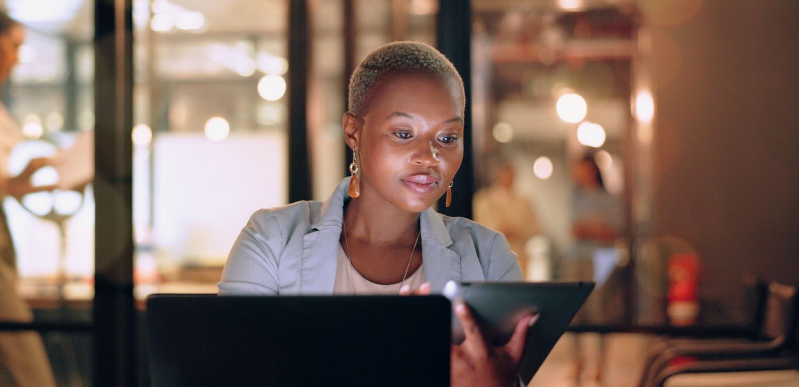 woman using a tablet with glass walls behind her